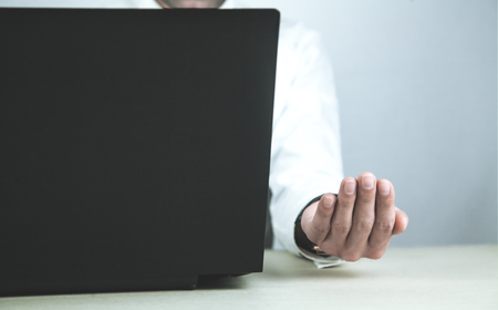 Businessman using laptop and showing empty hand.の写真素材