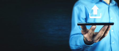 Man holding tablet with web upload icon.の写真素材