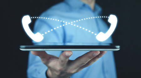 Man holding tablet with phone tube icons. Contact