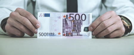 Caucasian businessman showing money in his desk.