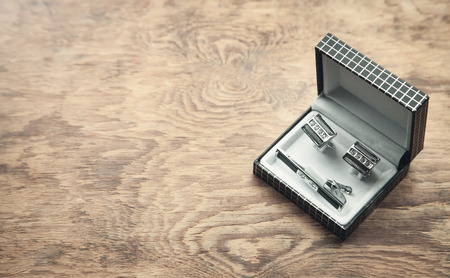 Cufflinks in a box on wooden background.の写真素材