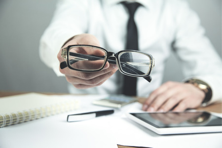Businessman showing glasses in his desk. Business conceptの写真素材