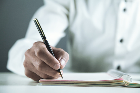 Businessman writing on a notepad in business desk.の写真素材