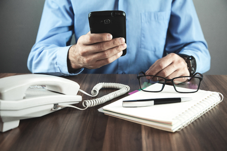 Man using smartphone in his desk. Business conceptの写真素材