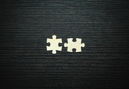 Puzzles on black wood background. Solution conceptの写真素材