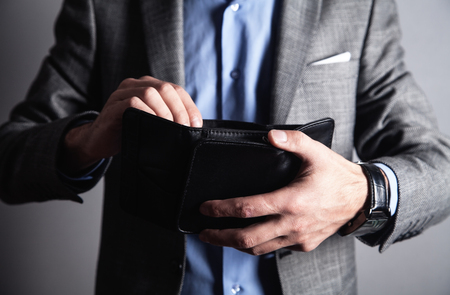 Caucasian man holding empty leather wallet.