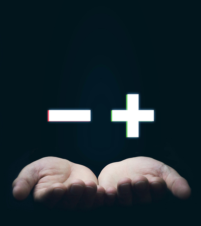 Hands holding plus and minus signs. Business conceptの写真素材