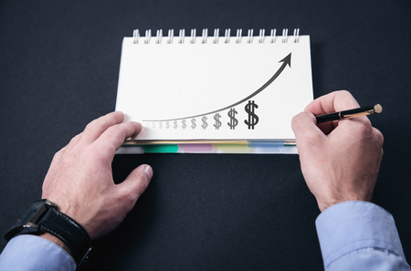 Man writing on notepad. Business concept. Financial chartの写真素材