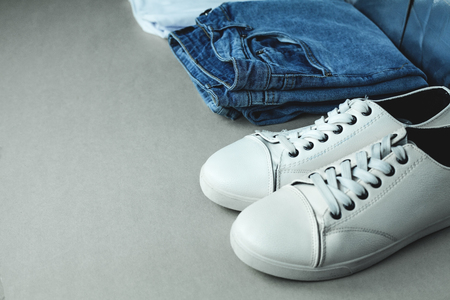 Blue jeans and white sneakers on gray background.の写真素材