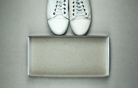 White sneakers with cardboard box on gray background.の写真素材