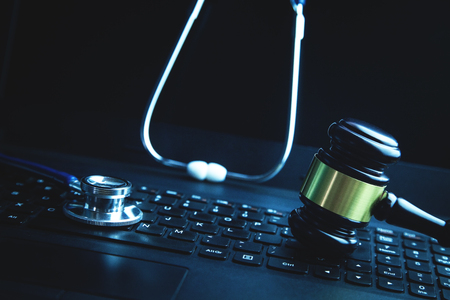 Gavel with medical stethoscope on laptop keyboard.の写真素材