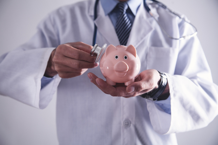 Medicine doctor holding piggy bank. Health Insuranceの写真素材