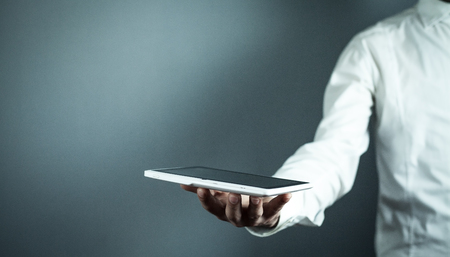 Man holding white digital tablet. Concept of new technologyの写真素材
