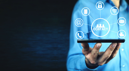 Man holding phone with contact icons.