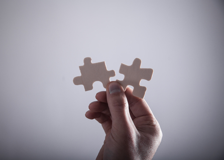 Hand holding two jigsaw puzzle piece. Success and Business