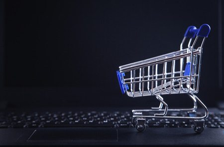 Shopping cart on laptop keyboard.