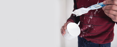 Man hands paintbrush with white paint. Renovationの写真素材