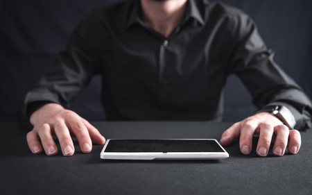 Man in black office desk with a tablet computer.の写真素材