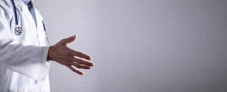 Medical doctor in white coat is offering his hand.の写真素材