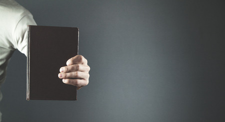 Caucasian man showing Holy Bible.