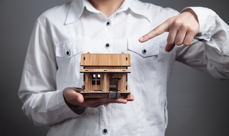 Business girl holding wooden house model.の写真素材