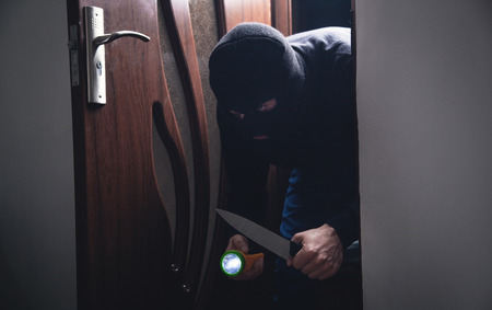 Murderer in black mask with a knife. Homicide and violence conceptの写真素材