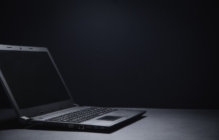 Black laptop on the black office desk. Technology conceptの写真素材