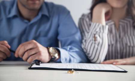 Couple with divorce contract and ring on desk. Divorceの写真素材