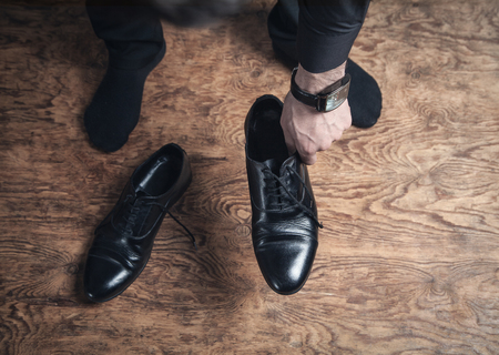 Man feet with black leather shoes on wooden floor.の写真素材