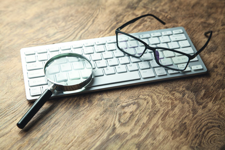 Magnifier with computer keyboard. Searching internetの写真素材
