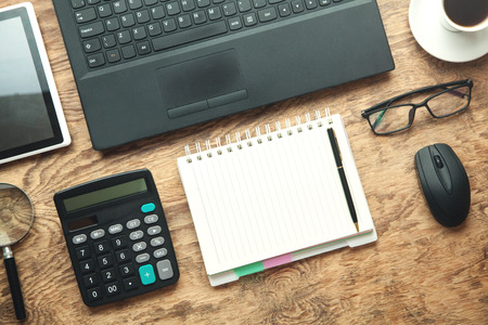 Office Workplace. Laptop, notepad, glasses on wooden desk.の写真素材