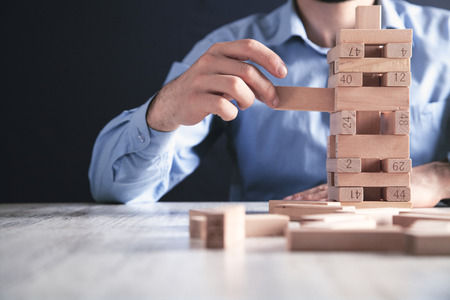 Man stacking wooden blocks. Development conceptの写真素材