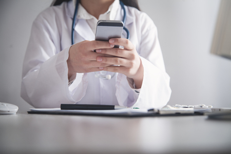 Doctor using mobile phone at clinic.の写真素材
