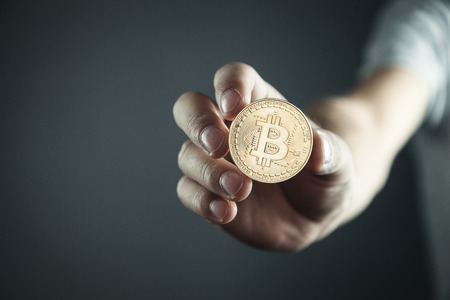 Businessman holding golden bitcoin. Virtual money conceptの写真素材