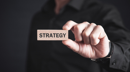 Man showing wooden block with Strategy word.の写真素材