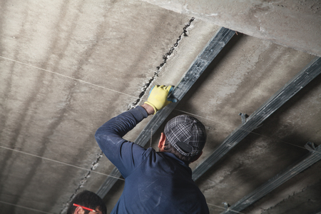 Working with a metal profile of a ceiling construction.の写真素材