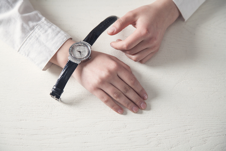 Girl hands with wrist watch on white desk.の写真素材