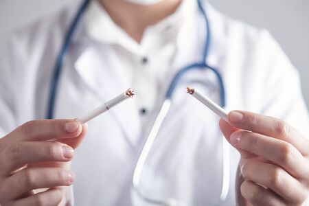 Doctor holding broken cigarette. Stop smokingの写真素材