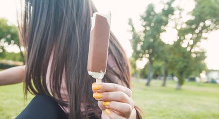 Beautiful woman showing ice cream in the park.の写真素材
