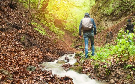 Man walking in forest. Water river in the forest