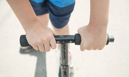 Boy on a scooter riding on the street.の写真素材
