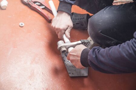 Worker connecting plastic pipe. Installing waterの写真素材