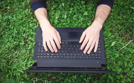 Man hands typing on laptop in outdoor.の写真素材