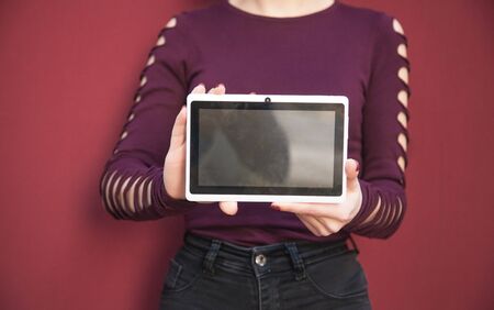Woman holding white digital tablet.の写真素材