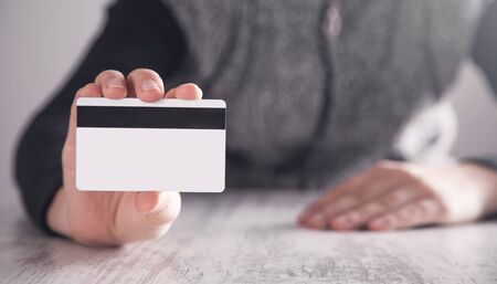 Girl showing credit card in office. Business