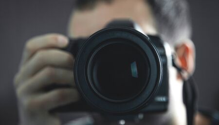 Professional photographer holding a DSLR camera.の写真素材