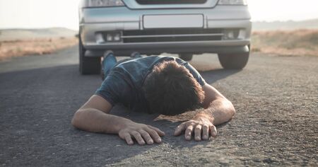 Caucasian injured man lying on asphalt. の写真素材