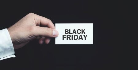 Male hand holding Black Friday text on business card.の写真素材