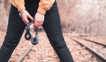 Girl holding headphones in outdoors.の写真素材