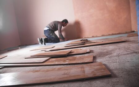 Worker installing new laminate wooden floor.の写真素材